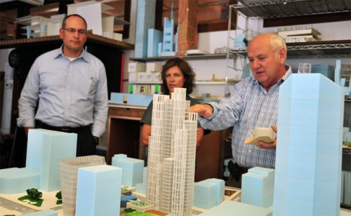 Jeanne Gang, center, shows a model of her design for CentrePointe to developer Dudley Webb, right, and structural engineer Ron Klemencic (Courtesy Studio Gang)