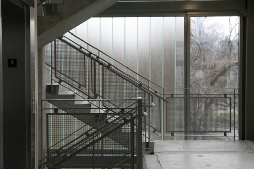Frosted glass panels clad the the stairwells at the building's corners.