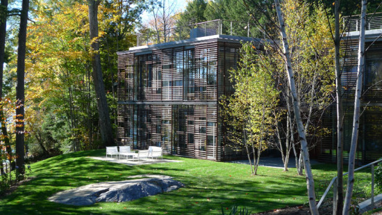 The two main buildings at GLUCK+'s Lakeside Retreat feature sliding wooden screens over massive glass curtain walls. (Courtesy GLUCK+)