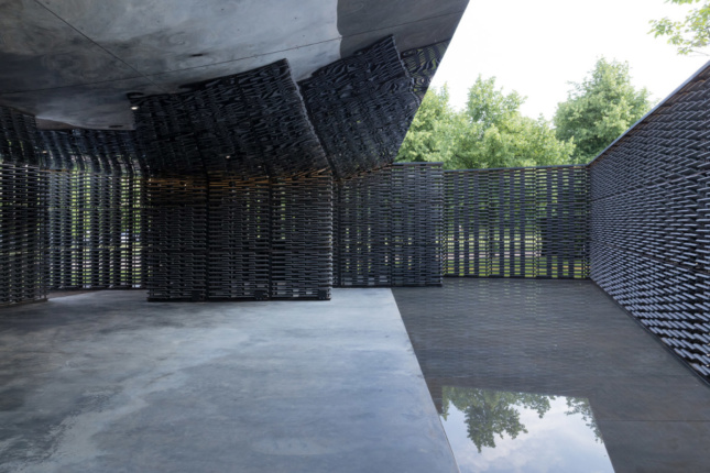 A mirrored canopy reflects the scene in the pavilion, while a reflecting pool bounces in light from above.