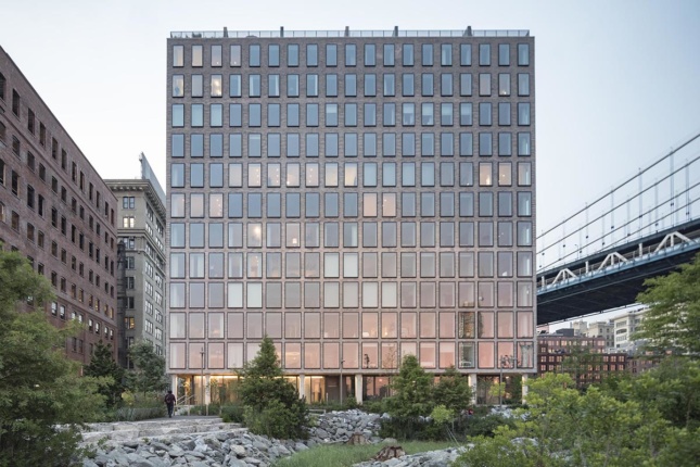 Exterior photo of 12-story square building next to park and Manhattan Bridge, an Alloy project