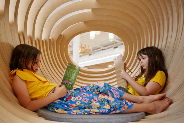 Children are afforded privacy inside the hovering plywood "cocoons."
