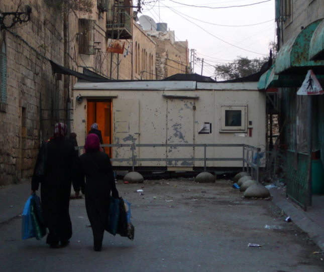 A checkpoint manned by Israeli Defense Force soldiers blocking the entrance to Shuhada Street, a formerly vital Palestinian market street in the Old City of Hebron.