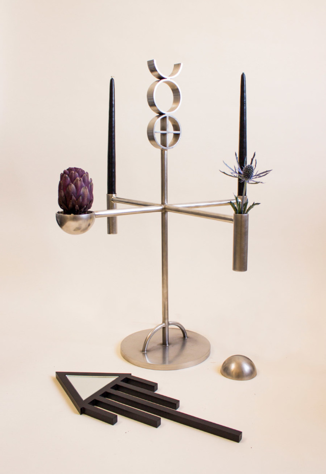 Alchemy Altar Candelabra features pagan and alchemical symbols cast in steel. The sculptures are a part of the symbolically dense Geometry Is God collection.