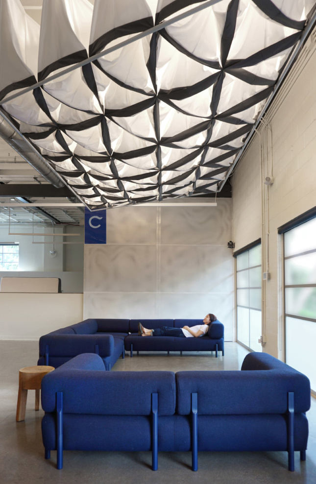 The Pillow Cloud by SAW incorporates Casper’s own pillowcases and floats above the main common space, softening sound and light for all-hands meetings or break-out groups. A custom sliding door, also made out of perforated steel, masks industrial shelving and storage areas while still offering a hint of what lies beyond.