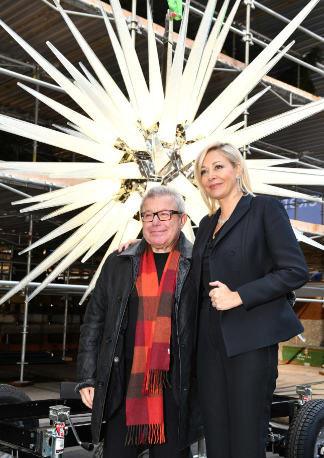 Photo of Daniel Libeskind and Nadja Swarovski posing in front of the Rockefeller Center Swarovski Christmas tree star
