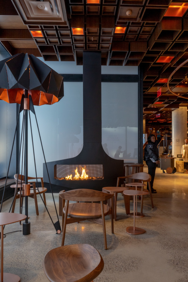 Starbucks Reserve Roastery New York lounge area by the front door features an active fireplace.