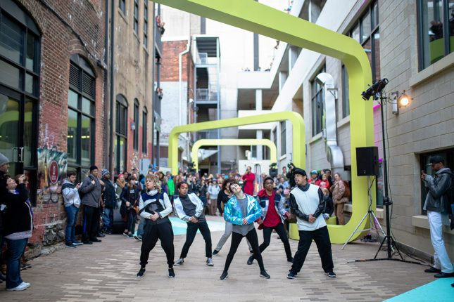 Photo of dance group performing in alley