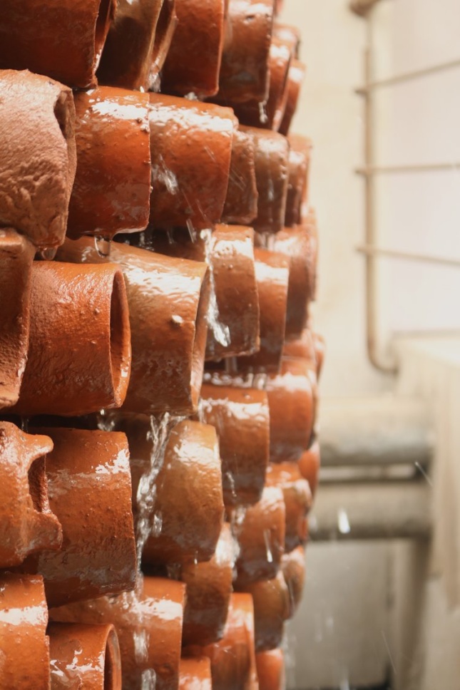 Photo of water running over terra-cotta pipes segments