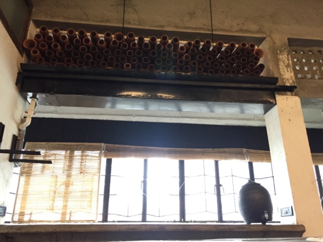 Photo of clay tubes installed in a wall above a set of windows