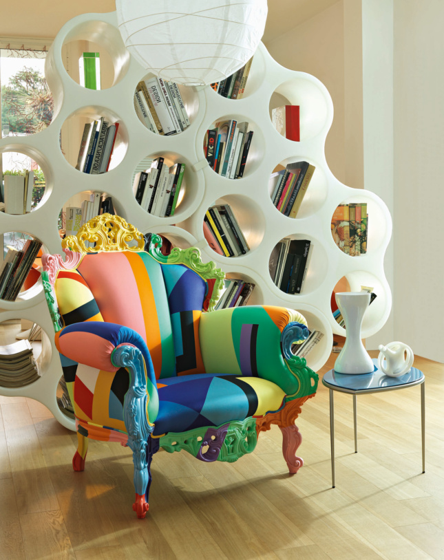 Photo of a multicolored Proust armchair in front of a bookshelf