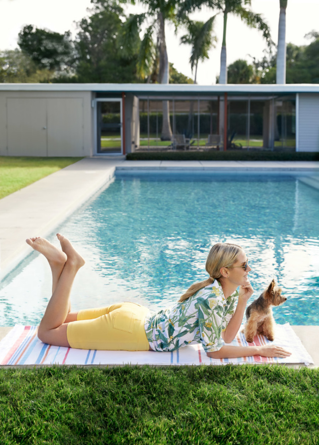 Woman lounging in front of a pool