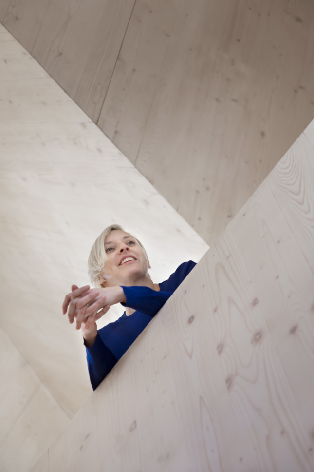 A woman leaning over timber construction