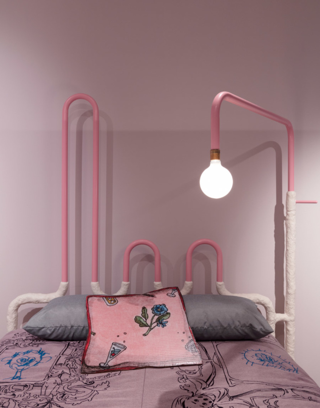 A pink bedroom with pipework lamp