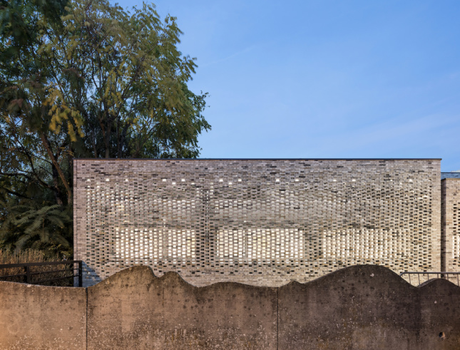 Photo of a concrete wall in front of a brick facade