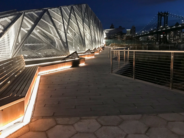 Photo of a waterfront walkway at night with lighting