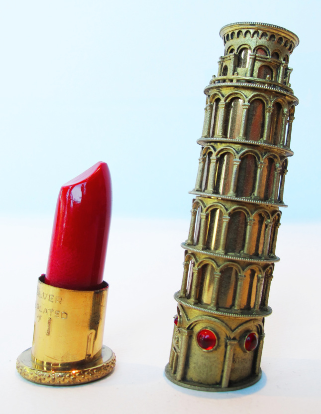 Photo of a small model of the leaning tower of Pisa next to a model of a tube of lipstick