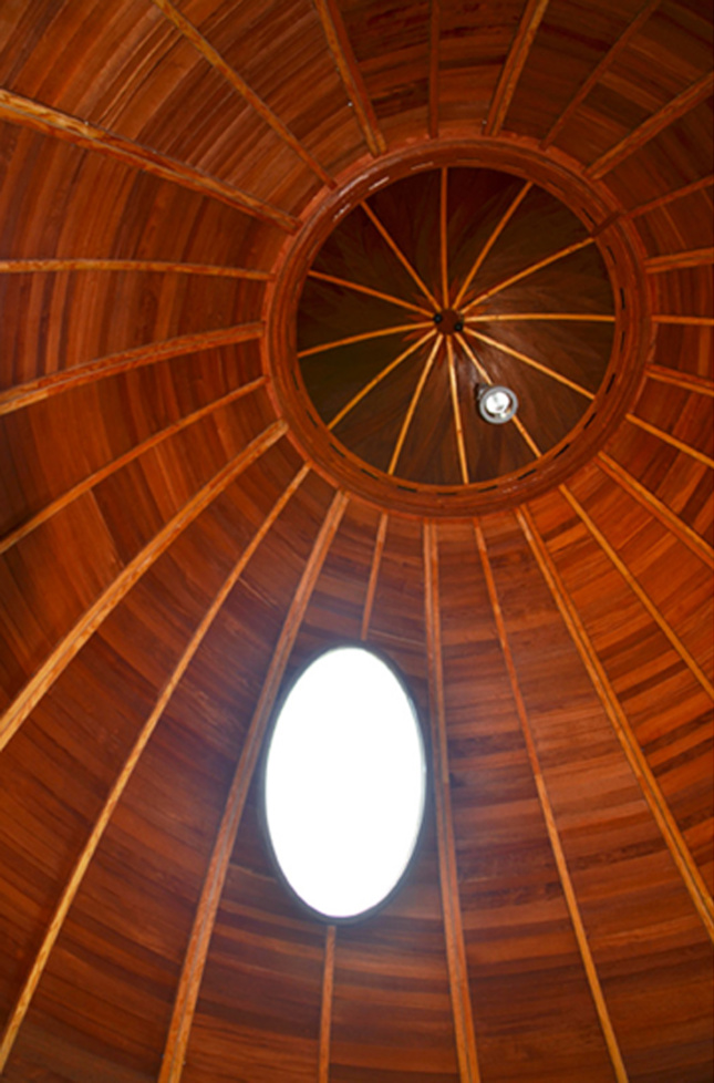 Photo of an egg-shaped room with an oculus and wood siding
