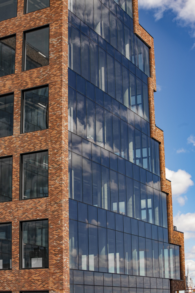 The building is split between glass curtainwall and draped brick