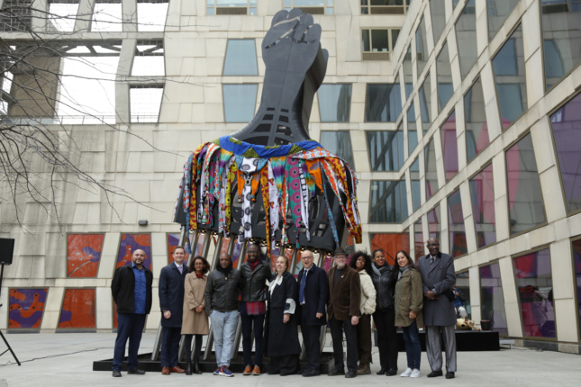 Group photo next to large-scale Afro pick sculpture