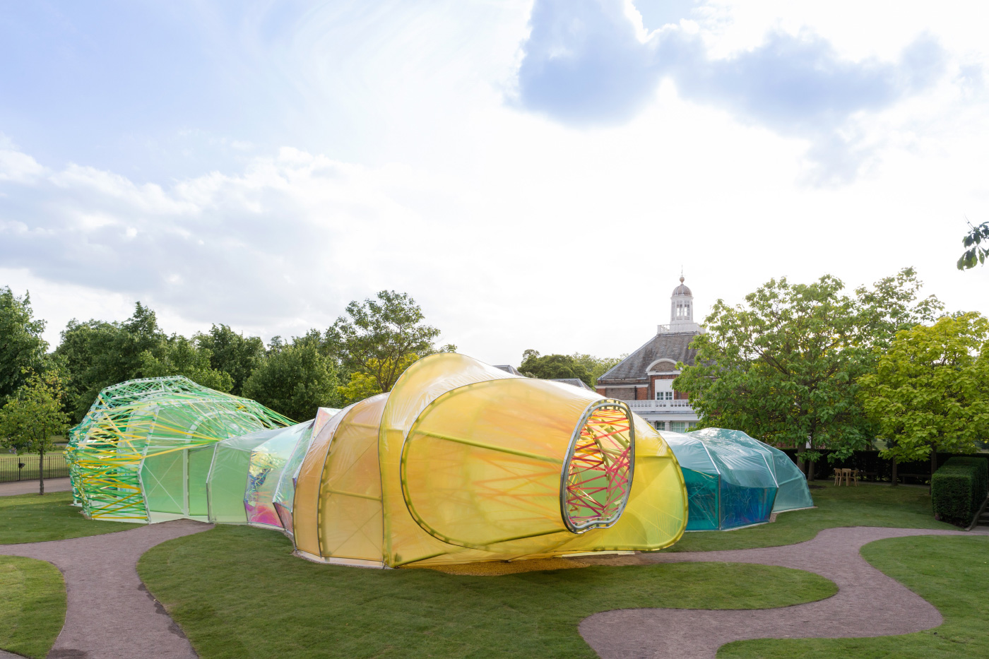 Photo of a large, multicolored fabric installation on an open lawn