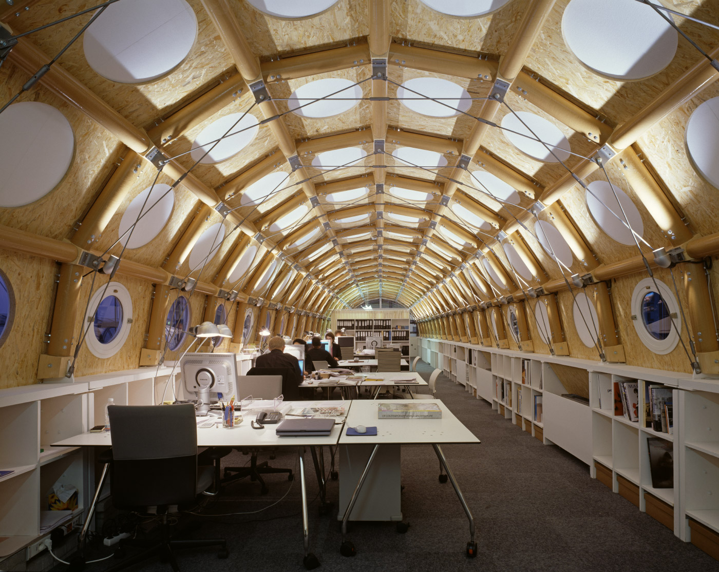 Photo of a mobile office inside of a semi-circle shaped space made of cardboard tubes