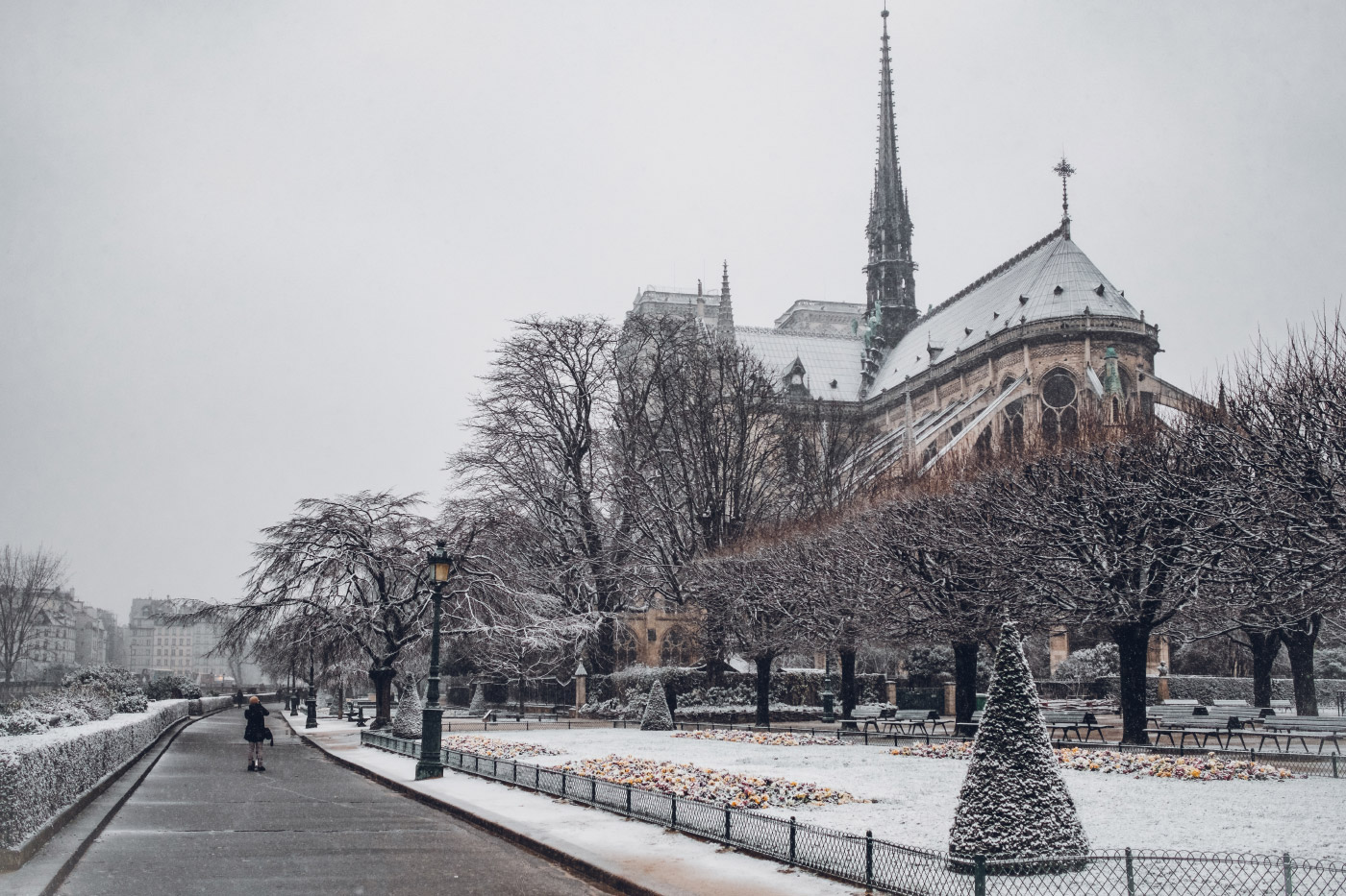 Photo of the Notre Dame cathedral in snow with a spire
