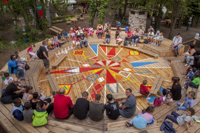 Photo of people sitting in a round wood seating arrangement