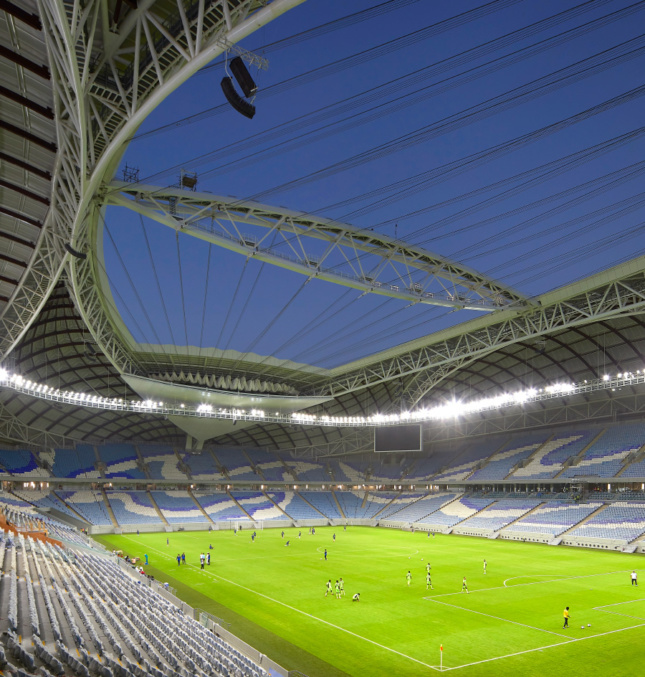 Ground-level view of a stadium roof, with a cable stay system at the center