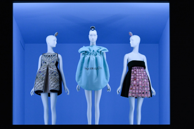 A blue display case with several dresses on display