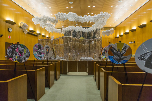 Photo of installation inside courtroom with art pieces hanging 