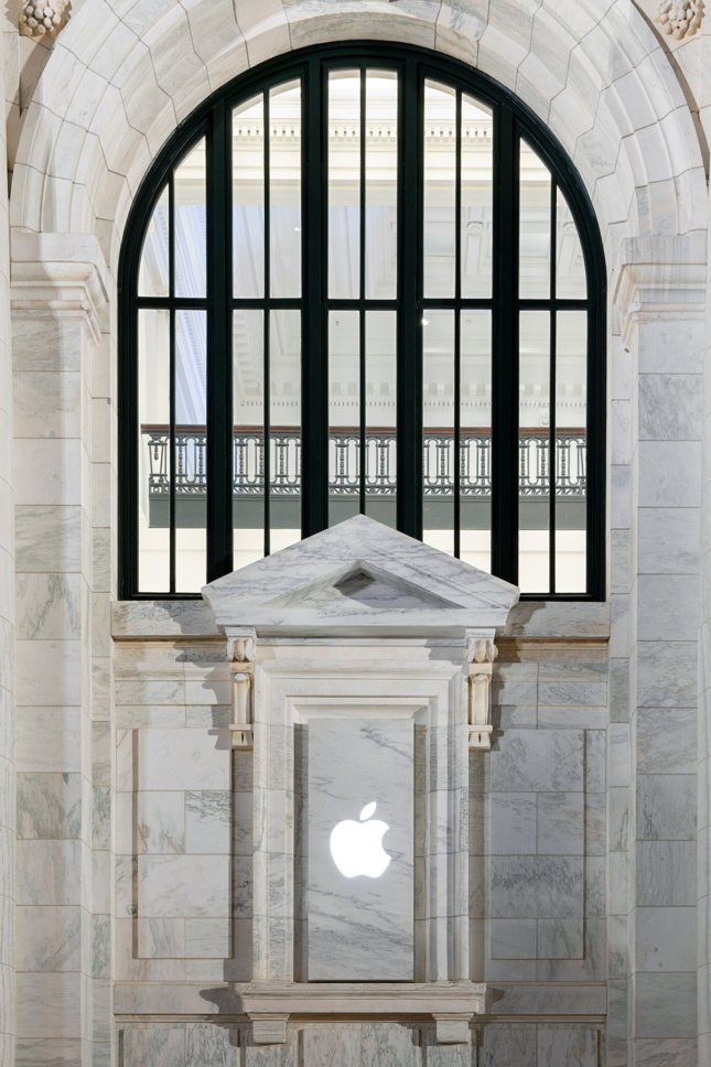 Photo of classical entablature in marble with a glowing Apple logo
