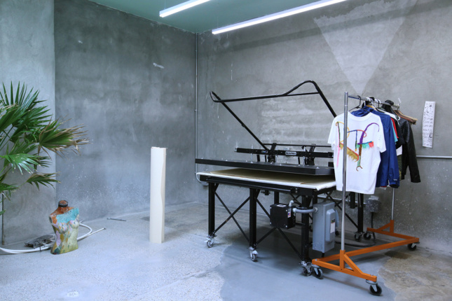 Photo of a screen printer in a concrete room
