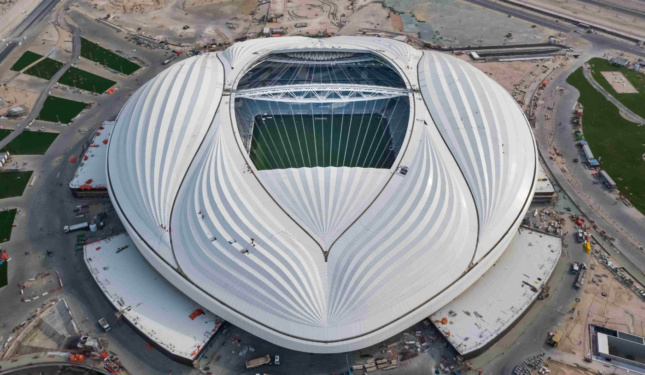 Aerial photo of a white, rounded stadium with curves