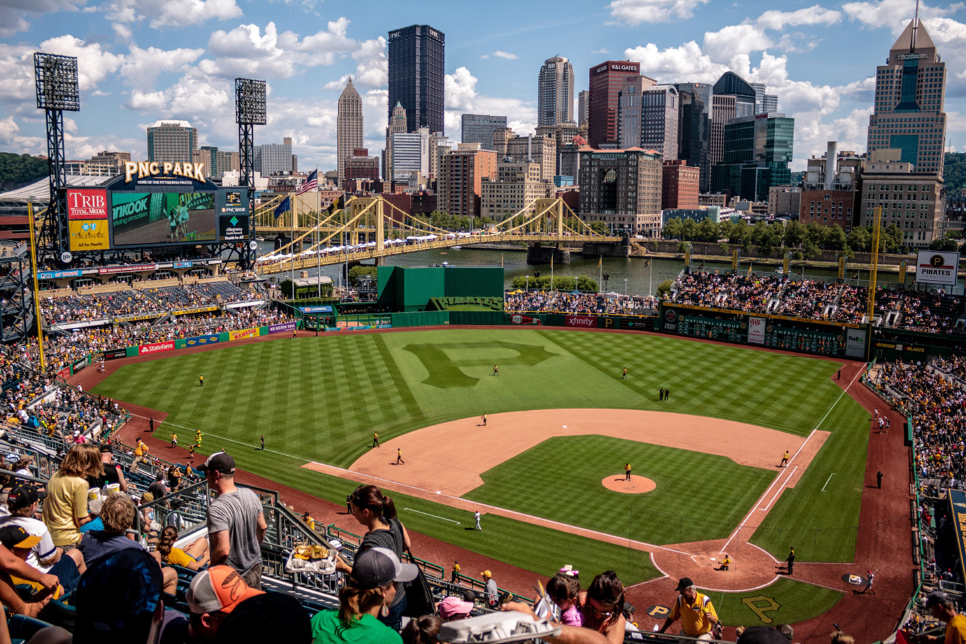 Photo of a ballpark with a skyline and bridge as a backdrop