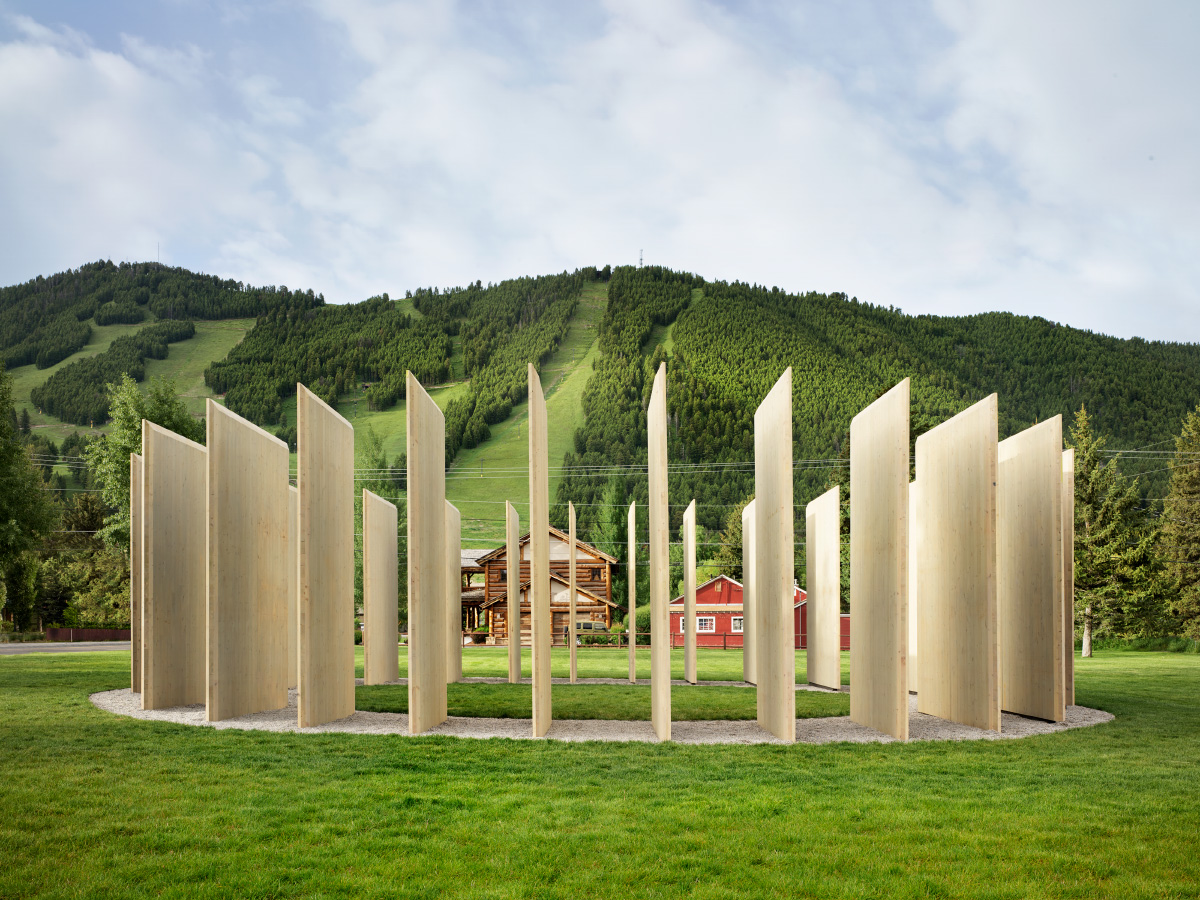 Photo of ring of raw timber panels arranged so that the mountain beyond is visible