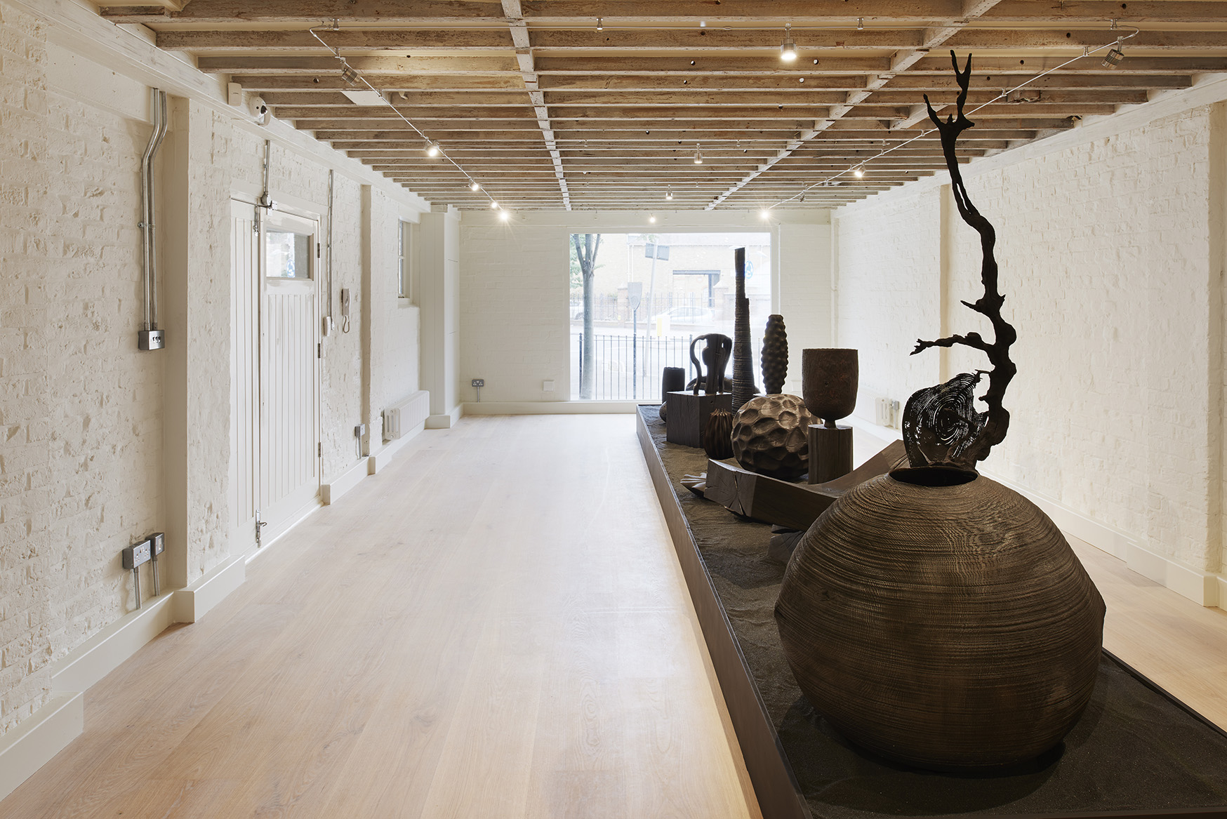 Interior photo of white wood flooring at the new Sarah Myerscough Gallery, with handcrafted design objects inside