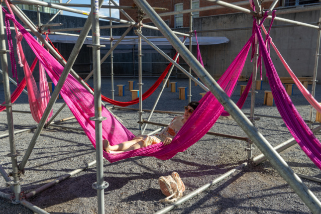 Red and pink hammocks hung between metal scaffolding