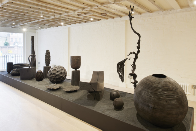 Interior photo of a white-wood gallery with handcrafted design objects inside