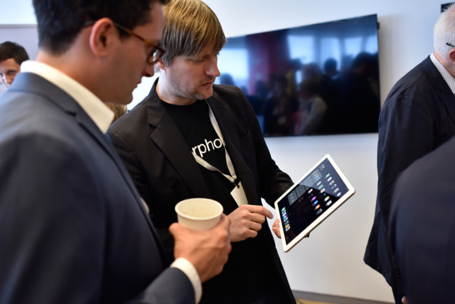 Photo of person showing another person data on an ipad