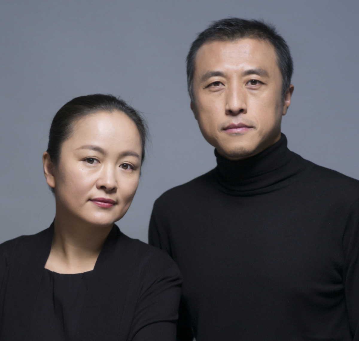 An Asian man and woman in black next to each other