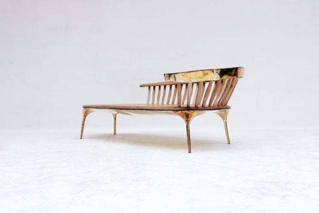 A bench with brass backing and wood seating