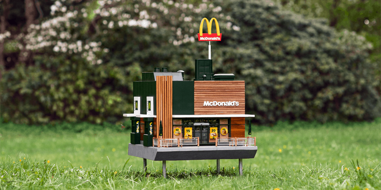 Photo of tiny McDonald's restaurant model sitting in a field