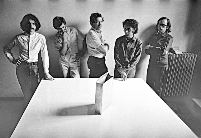 Image of five men around white table