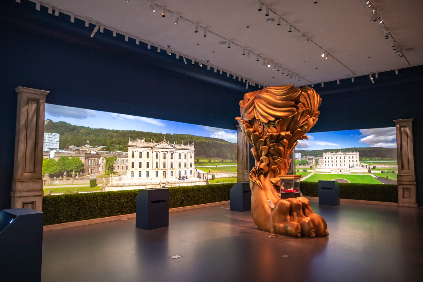 A 15-foot-tall lion's leg carved from wood in a double-height Sotheby's gallery