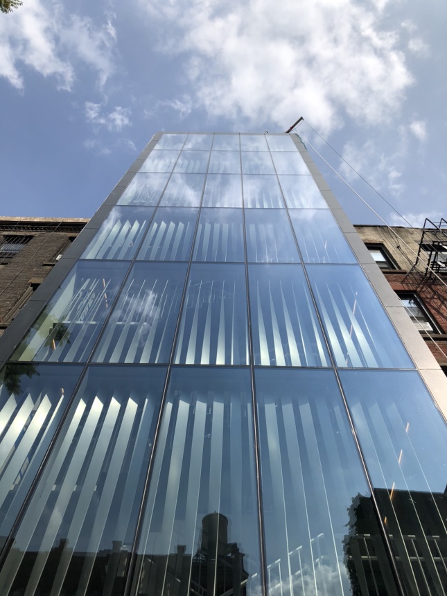 The rear of 277 Mott Street, a monumental glass curtain wall covering a stairwell