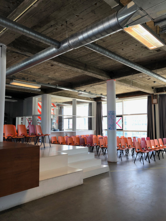 Interior photo of an industrial space with chairs and a bare ceiling
