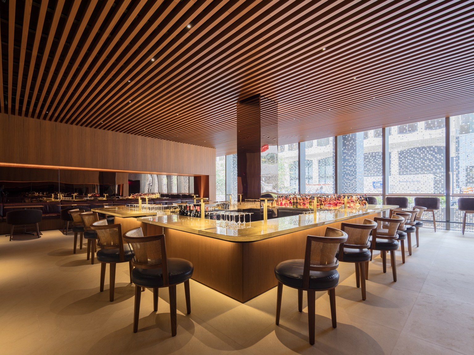 Interior of a warmly textured bar room with a wood ceiling, at the new Four Seasons