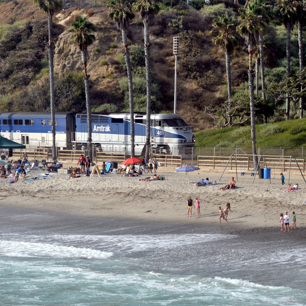 A train streaming along the California coast, threatened by sea level rise