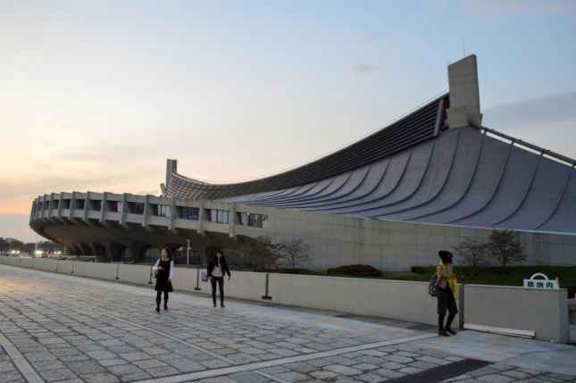 Exterior photo of concrete arena with swooping, wave-like design